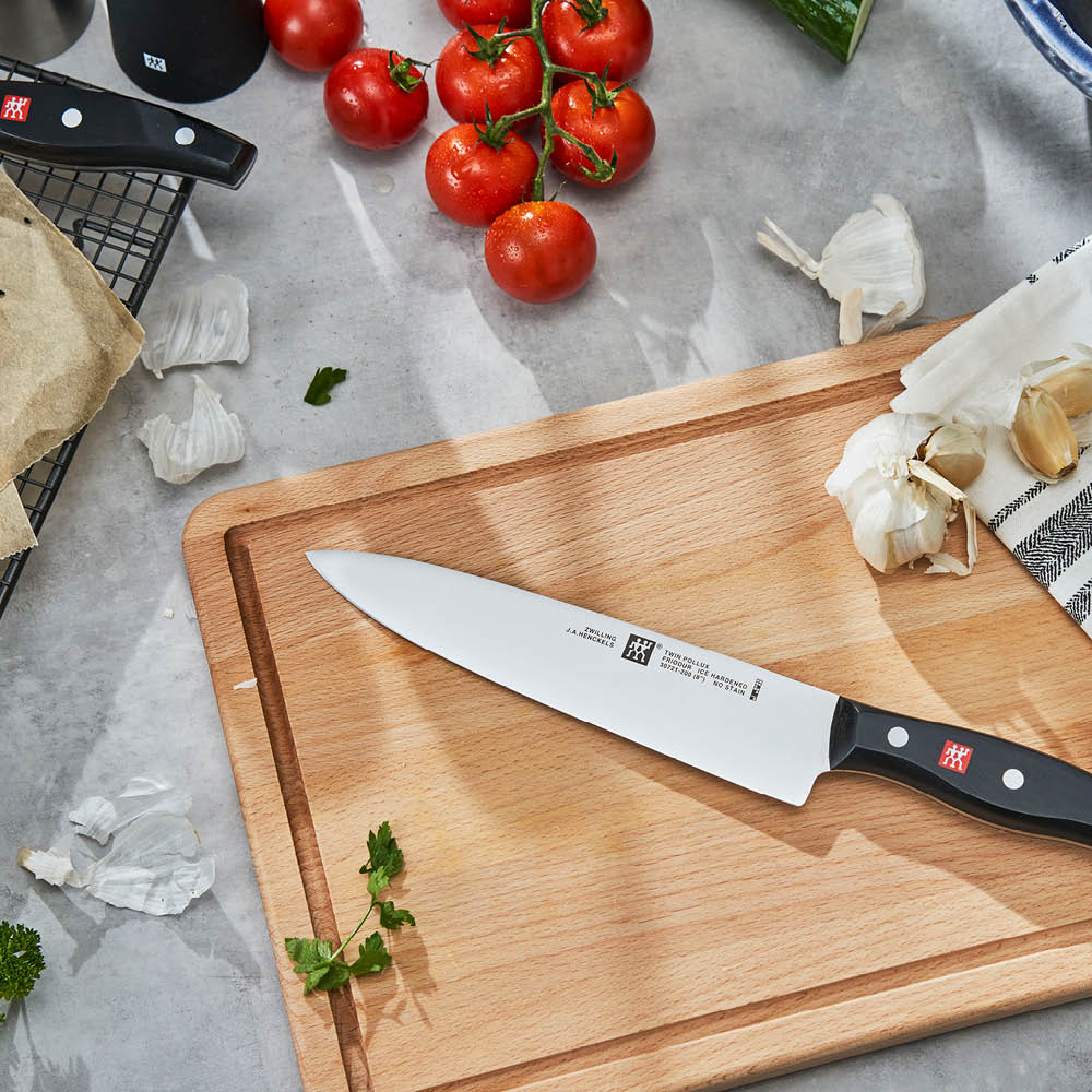 Cuchillo cebollero Zwilling Twin Pollux de 20 cm sobre tabla de corte de madera, herramienta clave para el Método Cocina Fluida.